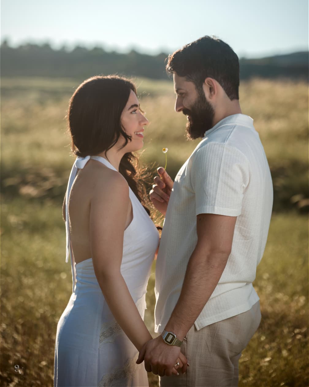 Amir and Lynn holding hands with a small daisy