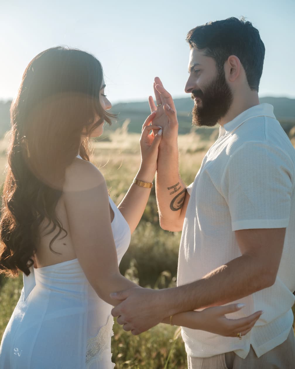Amir and Lynn touching hands in golden light
