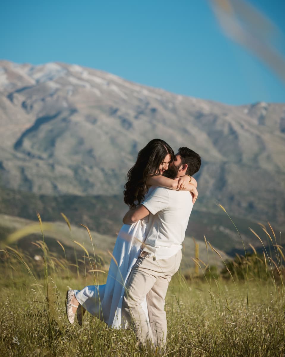 Amir lifting Lynn in a mountain field