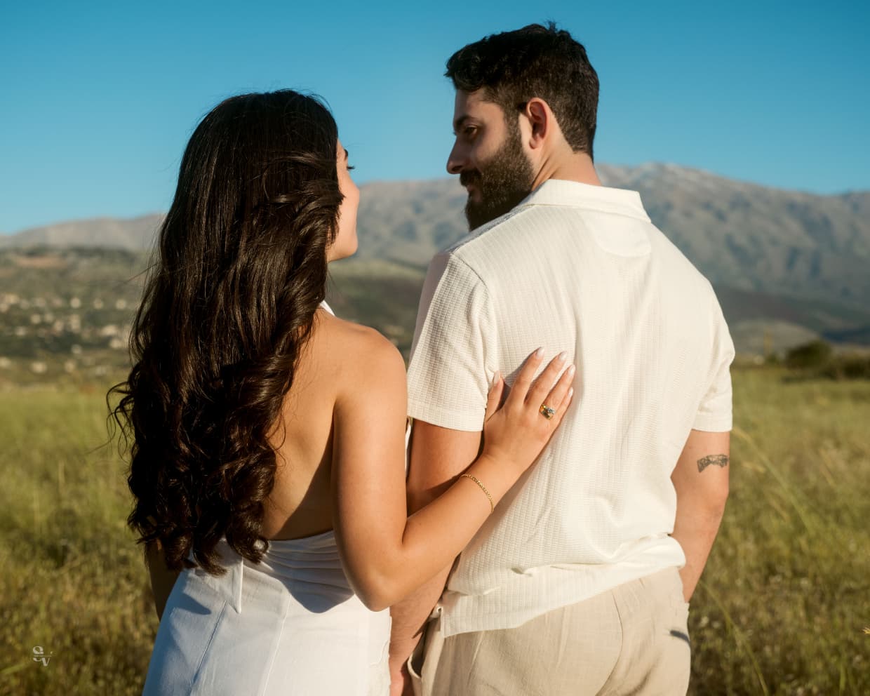 Amir and Lynn walking through a mountain field