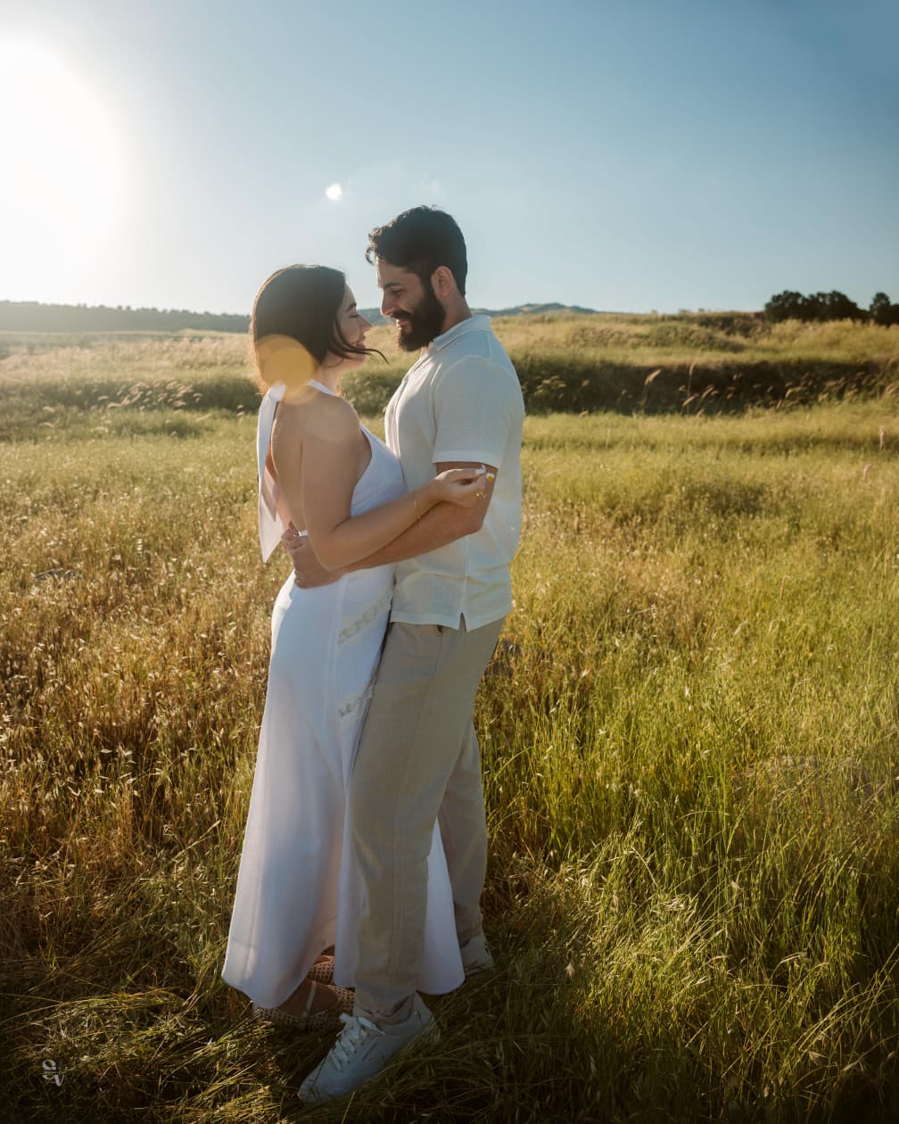 Amir and Lynn embracing in a sunny field