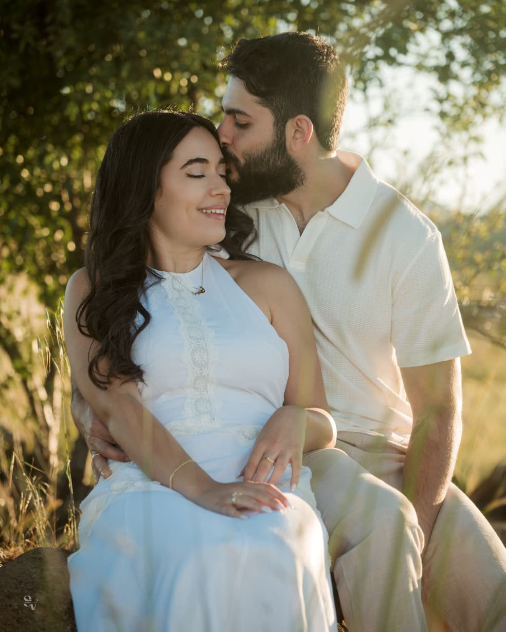 Amir kissing Lynn under warm trees